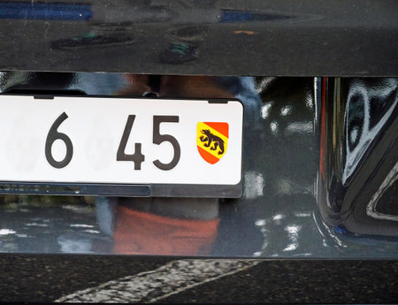Close-up of a Swiss license plate featuring the red and yellow emblem with a black bear, identifying the vehicle as registered in the canton of Bern, Switzerlandの写真素材