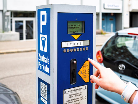 Basel, Switzerland - Sep 8, 2024: A central parking meter in Basel, Switzerland, with a female user selecting payment options in Swiss Francs and Euros. Blue design with instructional textのeditorial素材