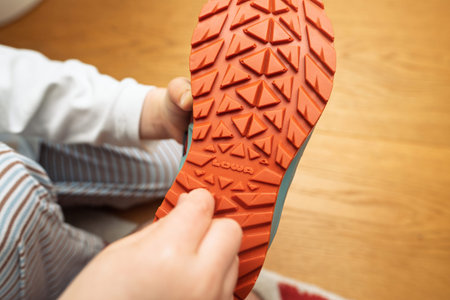 Paris, France - Apr 13, 2024: A close-up image of a Lowa shoe sole, featuring a vibrant orange tread...