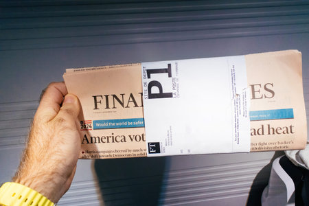 Paris, France - Nov 6, 2024: A hand holds the Financial Times newspaper wrapped in a postal band,...