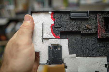 Close-up of a 3D printer component with white protective padding and red markings, highlighting intricate details and textured surface in industrial equipmentの写真素材