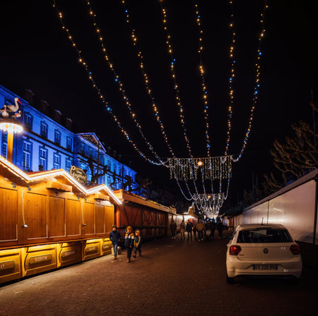 Strasbourg, France - Dec 23, 2024: Place Broglie in Strasbourg at night with festive lights still hanging, empty stalls, and a few people strolling after the annual Christmas market closureのeditorial素材