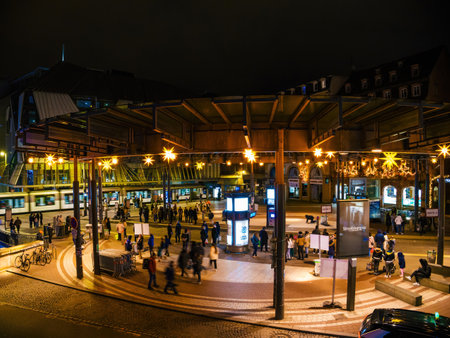 Strasbourg, France - Dec 23, 2024: Nighttime view of Place de lHomme de Fer in Strasbourg, with illuminated stars, a busy tram station, and people gathered in the squareのeditorial素材