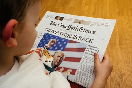 Paris, France - Nov 7, 2024: Curious toddler boy reading The New York Times with the headline Trump Storms Back, showing early interest in global news eventsのeditorial素材