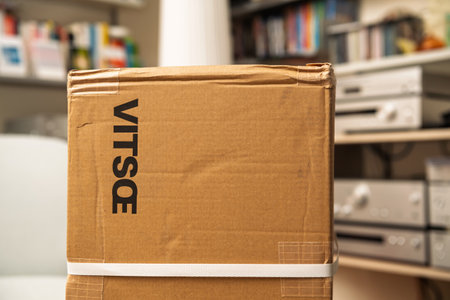 Frankfurt, Germany - Aug 21, 2024: A Vitsoe cardboard box with its logotype sits in a living room, surrounded by multiple shelves and hi-fi equipment, ready for unboxing the iconic design pieceのeditorial素材