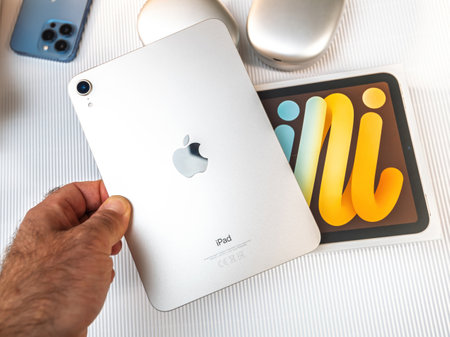 Paris, France - Oct 19, 2021: A fresh Apple iPad Mini being unboxed and held in hand, showcasing the sleek silver design, colorful display, and Apple Pencil compatibilityのeditorial素材