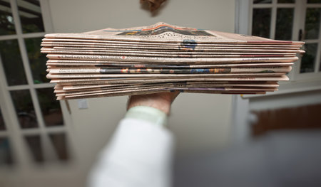 Paris, France - Oct 10, 2021: A hand holds a horizontal stack of Financial Times newspapers, reflecting global news coverage, economic trends, and the tradition of print mediaのeditorial素材