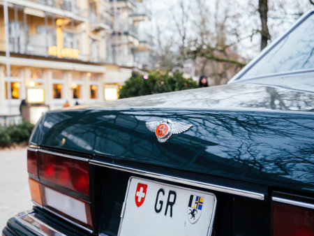Baden, Baden - Germany - Dec 1, 2024: Close-up of the rear of a green Bentley car with the iconic winged"B logo and a Swiss license plate in front of a hotelのeditorial素材