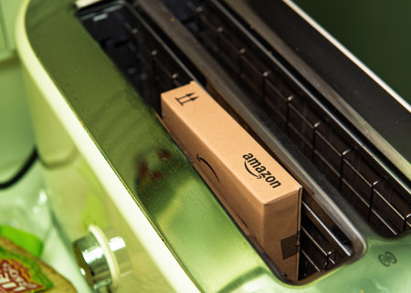 Paris, France - Nov 22, 2021: An Amazon cardboard box placed inside a toaster, creating a humorous and unusual scene in a kitchen settingのeditorial素材