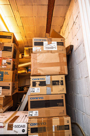 Frankfurt, Germany - Apr 21, 2024: A tall stack of labeled Onkyo Hi-Fi cardboard boxes stored in a utility room, showcasing organization and preparation for storage or shipment logisticsのeditorial素材