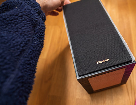 Paris, France - Apr 18, 2023: Unboxing Klipsch Reference bookshelf speaker featuring a sleek black grille with iconic copper woofer, positioned on a wooden table for displayのeditorial素材