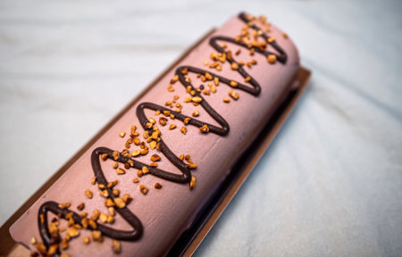 A decadent chocolate Buche de Noel decorated with zigzag chocolate drizzle and golden caramelized nuts, resting on a festive holiday trayの写真素材