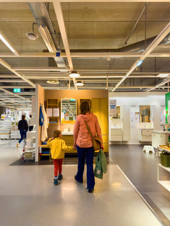 Paris, France - Oct 26, 2024: A mother and son walking together in an IKEA showroom, exploring stylish furniture setups and home decor inspirations.のeditorial素材