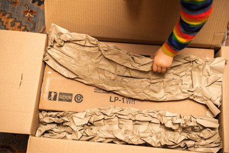 Paris, France - Nov 3, 2024: Child reaching into Yamaha LP-1WH box, helping to unpack and discover...