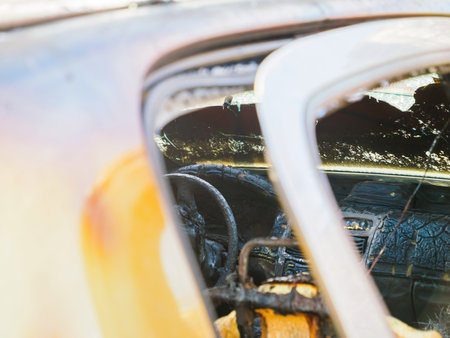 A close-up of a burned car's dashboard and steering wheel showing severe fire damage.の写真素材
