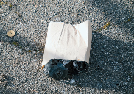 A partially melted and burned firework shell lying on the pavement, reflecting the aftermath of festivities.の写真素材
