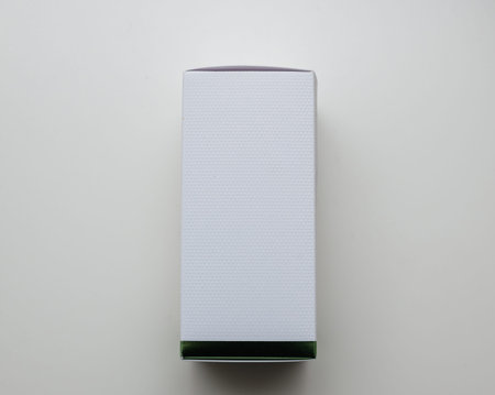 Side view of a sleek white textured packaging box with clean edges, showcasing a modern and minimal...
