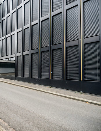A secured building features stainless steel jalousie windows, viewed from the street, highlighting...