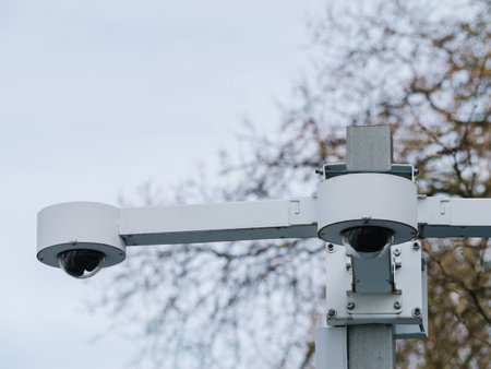 A close-up reveals two cameras firmly mounted on a pole, offering monitoring capabilities in an outdoor setting.の写真素材