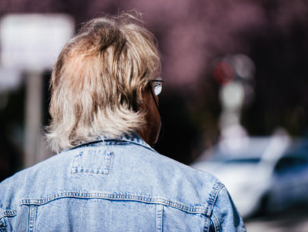A fashionable man sporting a denim jacket and glasses, exuding a confident and stylish vibe