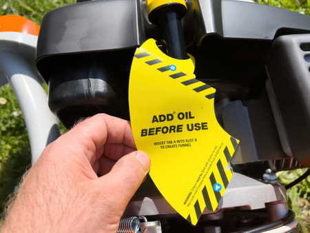 A vibrant yellow tag on a new machine advises to add oil before use, with clear instructions for creating a funnelの写真素材