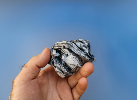 A hand grips a roll of tape with reinforced textile inside, set against a vivid blue background, highlighting its durability and versatility.の写真素材