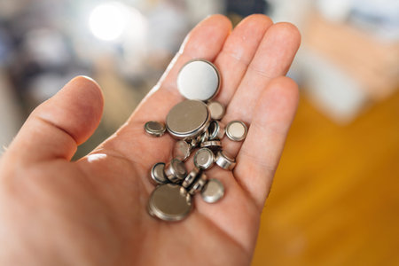 Button cells arranged in a mosaic pattern, cradled in an open palm