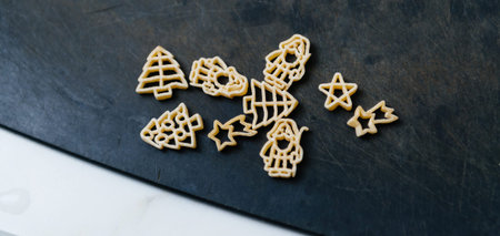 Close-up of uncooked Christmas-themed pasta, featuring shapes like trees, stars, and Santa figures...