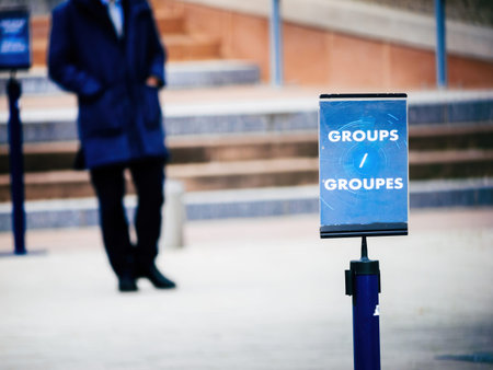 A blue sign labeled GROUPS GROUPES stands in the foreground, directing visitors, while a blurred...