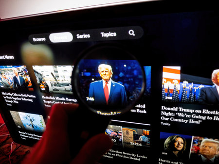 Paris, France - Nov 11, 2024: Magnifying glass held in front of a television screen zooming in on a news thumbnail of Donald Trump in a suit, surrounded by other political video headlines in a streaming interfaceのeditorial素材