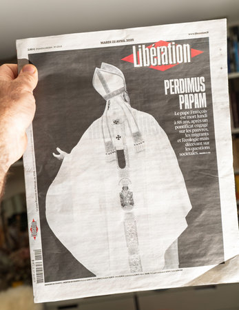 Paris, France - Apr 22, 2025: Liberation newspaper held in hand with cover image of a faceless Pope Francis and bold headline Perdimus Papam following his death at age eighty-eightのeditorial素材