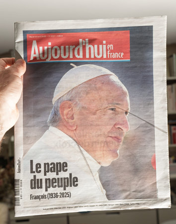 Paris, France - Apr 22, 2025: Aujourdhui en France front page held in hand features large portrait of Pope Francis with headline Le pape du peuple and tribute following his recent deathのeditorial素材