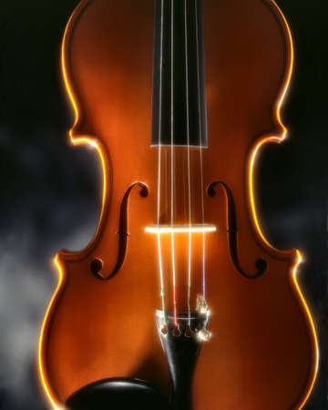 violin top-plate enlightened by a magic light in front of a dark fogの写真素材