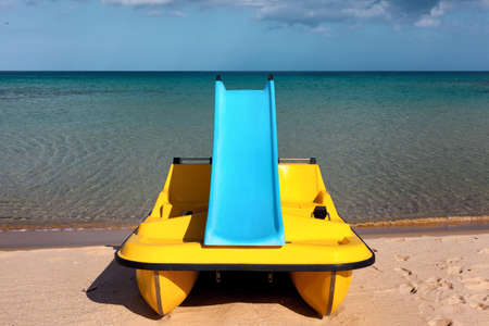 Paddle boat with water slide on the calm sea beachの写真素材