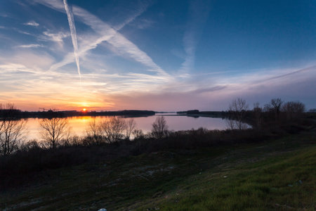 Sun setting over the river seen from the banks