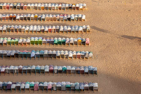 Lined and colored cabins on the golden sandy beachの写真素材