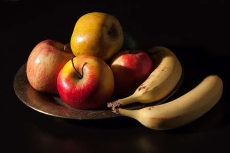 still life on black table with apples and bananasの写真素材