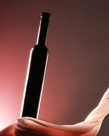 black bottle on pink background with silk clothの写真素材