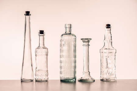 glass bottles of various shapes on a light backgroundの写真素材