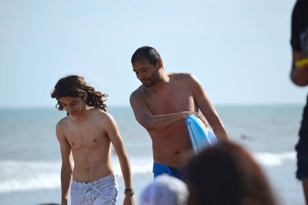 Father advises his son on the beachの写真素材