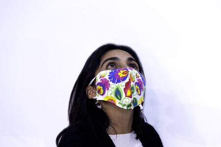 Young woman poses cheerfully with her chinstrap or mask. Positive attitude towards the coronavirus COVID 19 pandemicの写真素材
