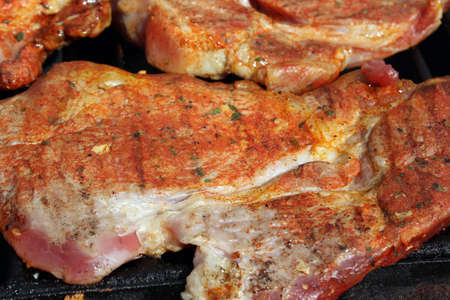 Pork neck getting grilled on open fireの写真素材