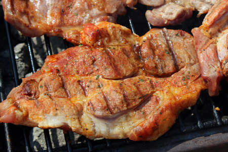 Pork neck getting grilled on open fireの写真素材