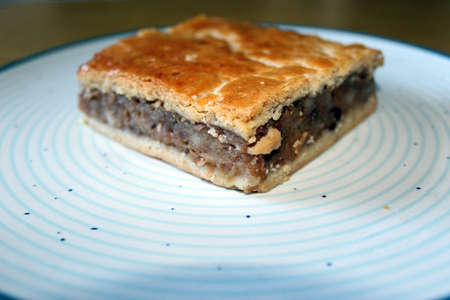 Romanian traditional apple cake, one square on a blue circles plateの写真素材