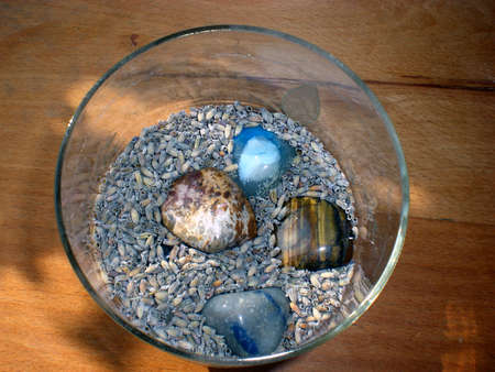 Semiprecious stones in a cup between lavender seedsの写真素材