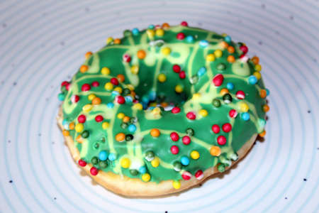 One green glazed doughnut isolated on blue circles plateの写真素材