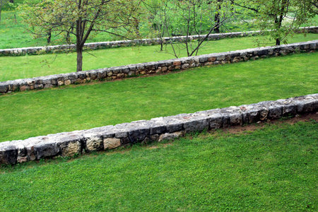 Ancient stone barriers in green garden landscapeの写真素材