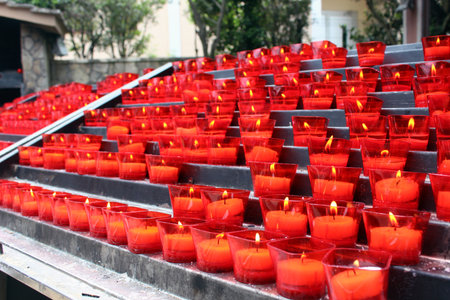 Burning red votive candles in prayer areaの写真素材