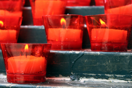 Burning red votive candles in prayer areaの写真素材