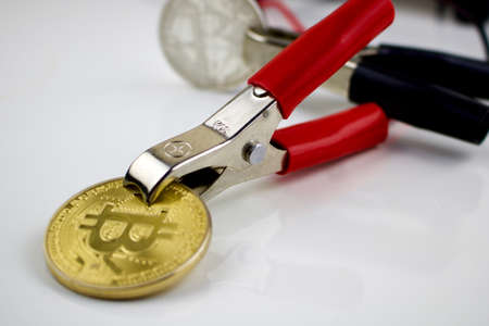 Gold cryptocurrency physical coin with electrical cablesのeditorial素材